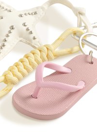 Porte-clés en métal avec une mini tong rose attachée, un cordon noué jaune et un ornement en forme d'étoile blanche avec des clous argentés.