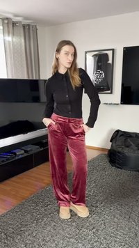 Fekete, hosszú ujjú, gombos ing keskeny szabással, hozzáillő plüss, bordó bársony nadrág oldalzsebekkel. A szettet bézs papucs egészíti ki.