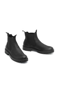Botas de tobillo de cuero negro con paneles laterales elásticos, puntera redonda y suela de goma resistente. Cuenta con lengüetas en la parte superior para facilitar el calzado y descalzado.