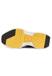 Suola di scarpa sportiva nera e gialla con modelli in gomma testurizzata, intersuola bianca e dettagli del logo in rilievo al centro.