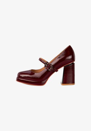 Scarpa Mary Jane in vernice bordeaux con punta arrotondata, tacco largo, cinturino alla caviglia e decorazioni con gemme.
