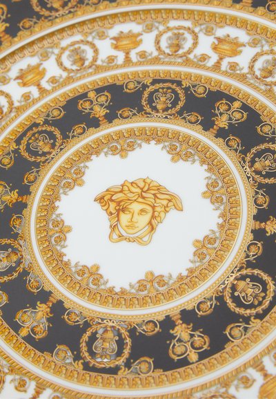 Στρογγυλό πιάτο με περίτεχνα χρυσά σχέδια σε σκούρο φόντο, με κεντρικό μοτίβο Μέδουσας και λεπτομερείς ανθισμένες δ�ιακοσμήσεις.