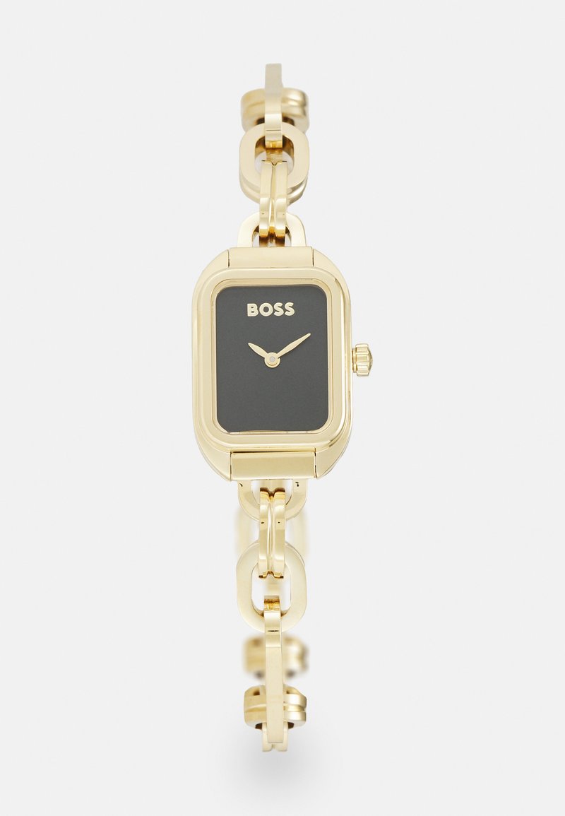 Montre rectangulaire dorée avec un cadran noir, design de bracelet à maillons et marque "BOSS". Caractéristiques des aiguilles minimalistes et d'une couronne.