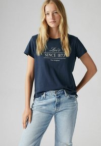 Camiseta de manga corta de color azul marino con el texto blanco "Levi's Since 1873" y "The Original" impreso en el frente; tejido suave, ajuste relajado.