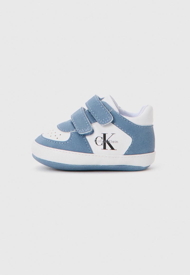 Blue suede children's sneakers with white accents, dual Velcro straps, and a logo on the side. Rounded toe and textured sole.