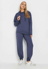Dunkelblaues Hoodie- und Jogginganzug-Set aus weichem Stoff. Das Hoodie verfügt über einen Kordelzug, während die Jogginghose elastische Bündchen und eine lockere Passform hat.