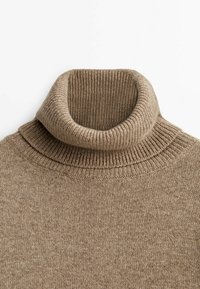 Pull à col roulé côtelé beige avec col plié, texture douce et détails de couture fins.