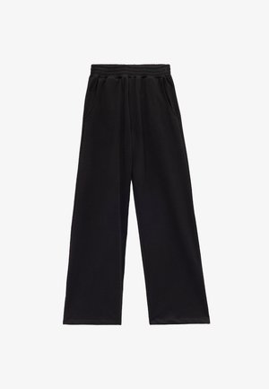 Czarne szerokie dresy wykonane z miękkiego, elastycznego materiału. Posiadają elastyczny pasek w talii i dwie boczne kieszenie dla większej funkcjonalności.