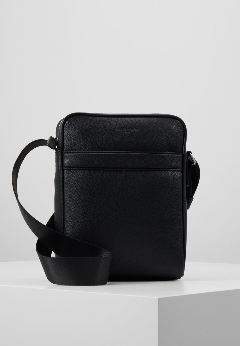 Borsa a tracolla nera in pelle con finitura texture, forma rettangolare, chiusura con zip superiore e tracolla regolabile. Design minimalista con tasca frontale.
