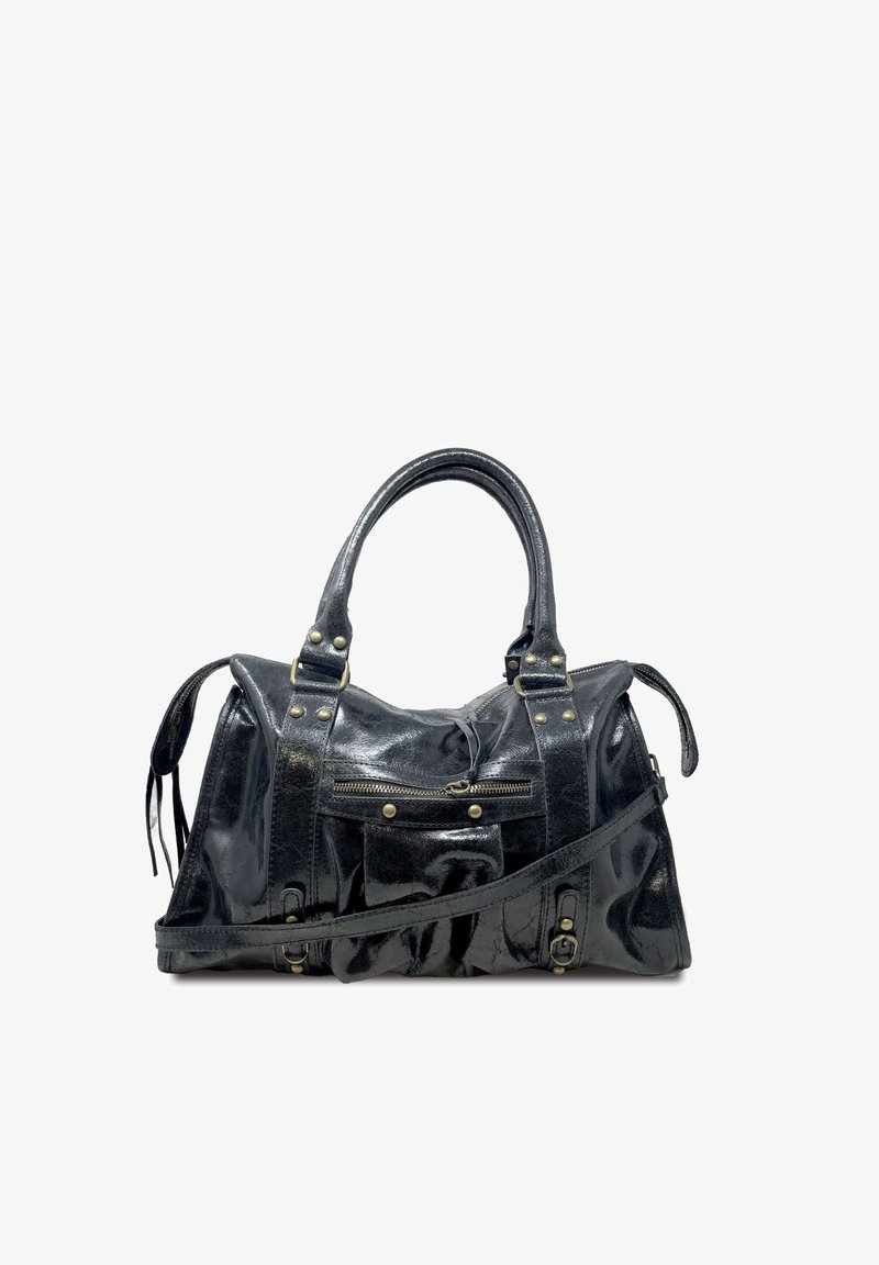 Musta, kiiltävä nahkalaukku, jossa on kaksinkertaiset yläkahvat ja irrotettava olkahihna. Varustettu useilla vetskareilla ja messinkikoristeluilla. Raskasti teksturoitu pintamateriaali.