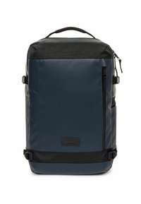 Mochila azul marino con acabado suave, detalles en negro y forma estructurada. Cuenta con hebillas laterales, bolsillo frontal con cremallera y asa superior.