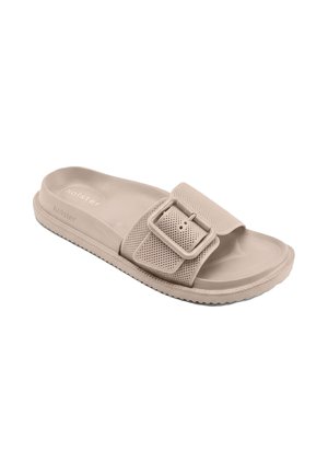 Sandale à talon beige avec semelle texturée, bride perforée réglable, grande boucle carrée et semelle nervurée pour une meilleure adhérence.