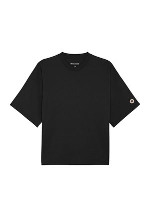 T-shirt noir à manches courtes avec col rond et petit patch circulaire sur la manche gauche.