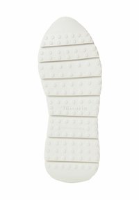 Vit gummisula med texturerade greppmönster, segmenterad design och varumärket "Tamaris" präglat. Tillverkad i Portugal.