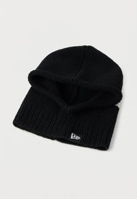 Μαύρο πλεκτό σκούφο με ριγωτή υφή και διπλωμένο γείσο. Διαθέτει μια μικρή μαύρη και λευκή ετικέτα-λογότυπο στο πλάι.