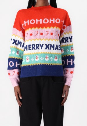 Osoba ubrana w kolorowy sweter świąteczny z napisami „HOHOHO”, „MERRY XMAS” i wzorami bałwana na czerwonych, różowych, miętowych i granatowych paskach.