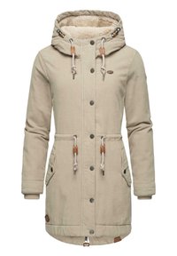 Beige korduroy kappa med en pälsfodrad huva, framfickor, snoddar, trädetaljer, tryckknappar och dragkedja i botten.