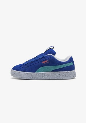 Blue suede sneaker with textured upper, turquoise accents, and speckled gray rubber sole. Features rounded toe and flat laces.
