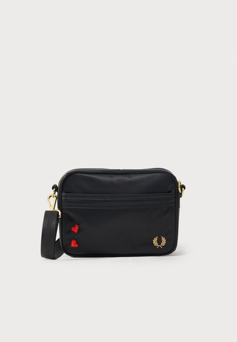 Μαύρη ορθογώνια τσάντα ώμου με χρυστό φερμουάρ, ρυθμιζόμενο ιμάντα, δύο κόκκινες καρδιές και χρυσό λογότυπο δάφνινο στεφάνι μπροστά.