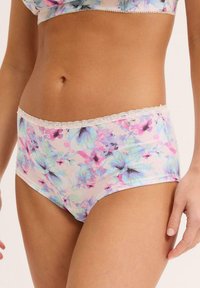 Culotte a vita alta con stampa floreale in tessuto morbido, caratterizzate da un leggero pizzo e una palette di colori pastello che include tonalità di rosa, blu e viola.