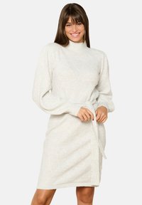 Light gray knitted dress with a fitted silhouette, turtleneck, and belted waist. Features textured diamond patterns and long sleeves.
