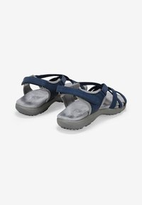 Sandali blu navy con molte cinghie incrociate, suole in gomma grigia e plantari imbottiti per il comfort. Presentano una cinghia posteriore regolabile.