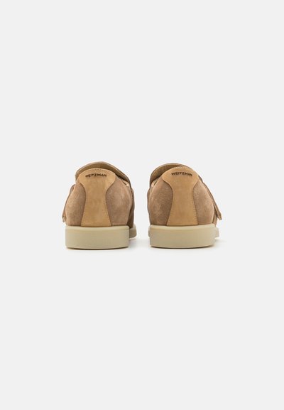 Baskets en suede marron à profil bas, avec une texture lisse, un bout arrondi et une semelle en caoutchouc de couleur claire. Logo sur le talon.
