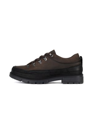 Brown leather hiking shoes with a low profile, featuring silver hardware eyelets, a textured black rubber sole, and a rear pull tab.
