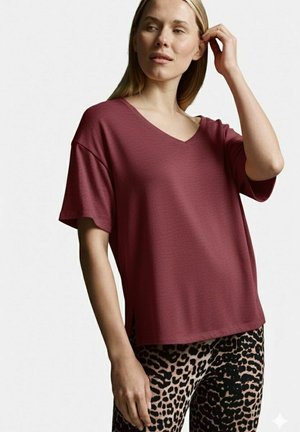 Burgunderfarbener V-Ausschnitt-T-Shirt mit kurzen Ärmeln, kombiniert mit schwarzen und beigen Leggings im Leopardenmuster. Weicher, strukturierter Stoff.