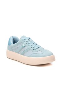 Zapatillas de color azul claro con parte superior de ante y tela, diseño de cordones y suela gruesa y texturizada de color crema. Tres franjas en el lateral.