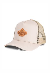Vaaleanbeige trucker-lippalakki, jossa on teksturoitu etupaneeli, verkkosivut, kaareva lippa ja ruskea nahkalaminaatti, jossa on "BLACKSKIES"-logo.