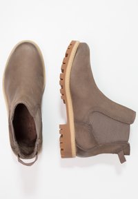 Braune Lederstiefel mit elastischen Seitenpaneelen, Gummilaufsohlen und Zuglaschen. Glatte Textur und runde Zehenform.