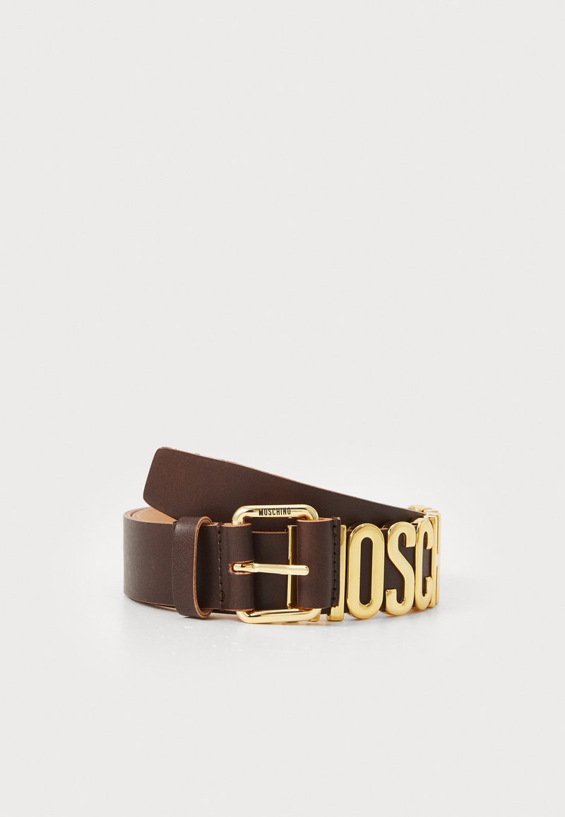 Hnedý kožený pás s hladkou textúrou, ktorý má veľkú pracku v zlatej farbe s nápisom "MOSCHINO" a klasickým uzatváraním na kolík.