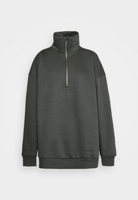 Sweat-shirt vert foncé avec un col montant, une demi-fermeture éclair et des manches longues. Confectionné dans un matériau lisse avec une coupe décontractée et des poignets côtelés.