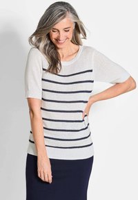Gestreifter Strickpullover mit kurzen Ärmeln, der eine hellcremefarbene Basis und marineblaue Streifen aufweist. Weiche Textur und lockere Passform.