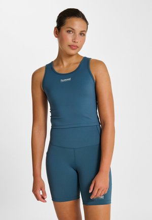 Athletisk todelt sæt i teal, der omfatter en tætsiddende tanktop med brede stropper og højtaljede shorts med subtil tekstur og logodetalje.