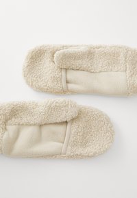 Cream-colored plush slippers with a soft, textured exterior and a smooth inner lining. Designed with a simple, rounded shape.