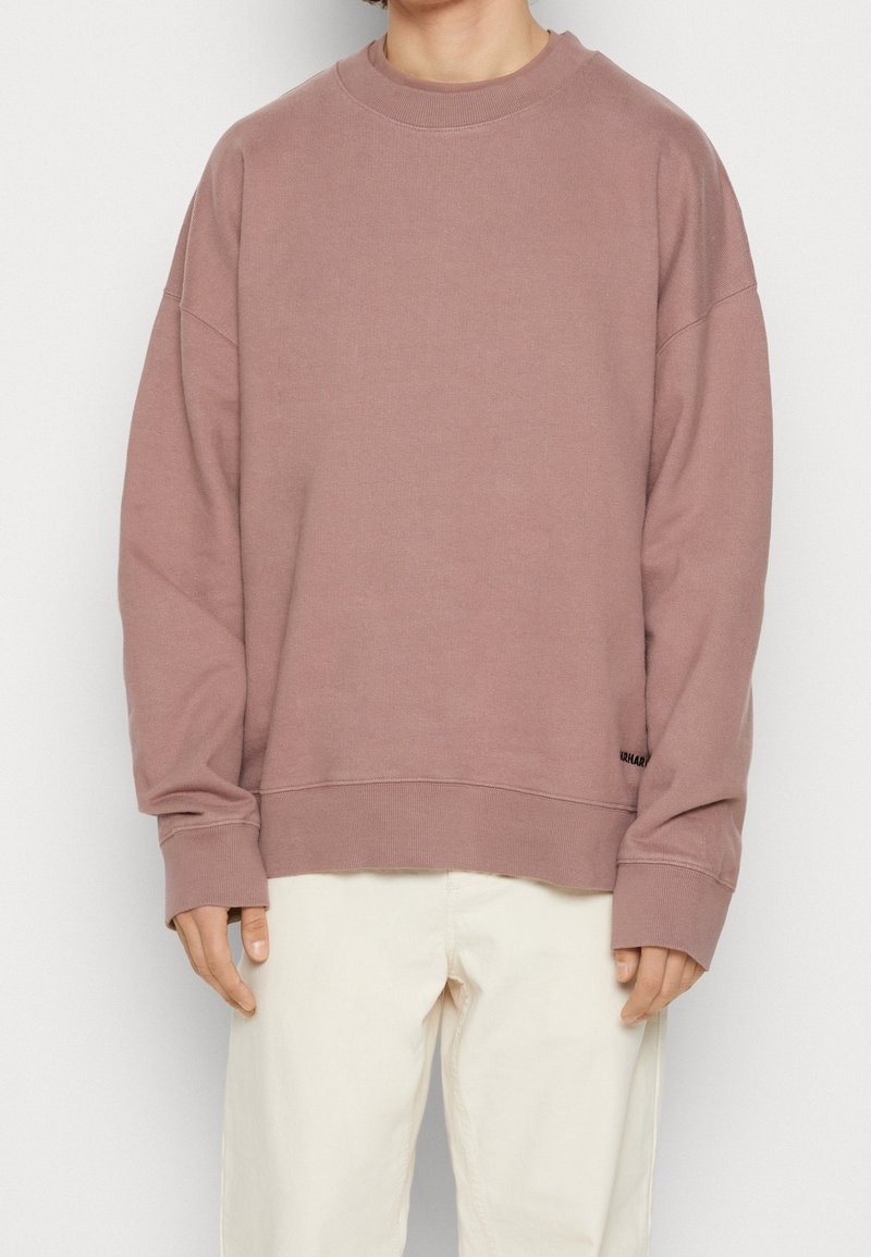 Übergroßer, mauvefarbener Pullover mit Rundhalsausschnitt, gerippten Bündchen und Saum; weiche Stoffstruktur mit Logodetail unten links.