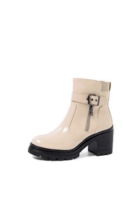 Stivale alla caviglia in pelle verniciata beige con tacco spesso nero, zip laterale e una cinghia decorativa con dettaglio fibbia.