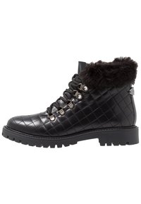 Botas negras de cuero acolchado hasta el tobillo con cuello de piel sintética, diseño con cordones, ojales metálicos y suela de goma resistente.