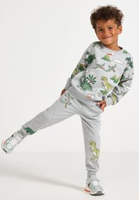 Gray sweatshirt and sweatpants set featuring dinosaur prints in green and yellow, with a soft, textured finish and elastic cuffs.