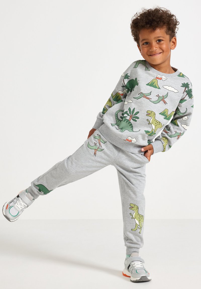 Gray sweatshirt and sweatpants set featuring dinosaur prints in green and yellow, with a soft, textured finish and elastic cuffs.