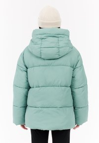 Chaqueta acolchada de material suave en verde menta. Cuenta con capucha, corte oversize, puños acanalados y detalles de costura horizontal.