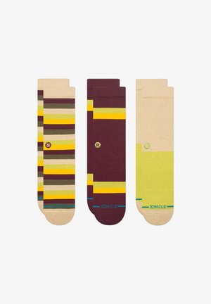 Três pares de meias: um com riscas multicoloridas em bege, um bordeaux com acentos em amarelo e uma verde clara sólida com bege.