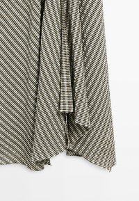 Tissu rayé diagonal noir et blanc avec un motif tissé texturé, drapé et suspendu avec des plis visibles.
