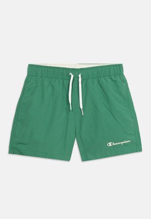 Grønne shorts med elastisk talje, hvid snor og Champion-logo på venstre nedre ben.