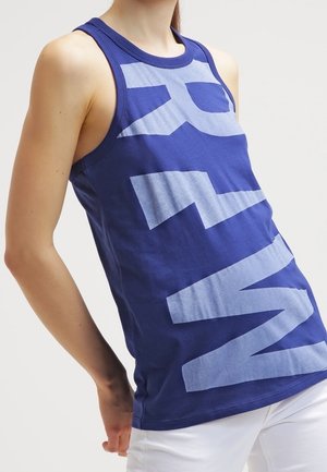 Top in cotone blu con una grande scritta azzurro chiaro. Presenta un collo rotondo e ampi fori per le braccia, silhouette aderente.
