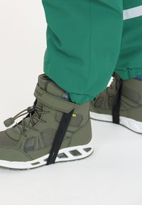 Grønne høj-top sneakers med en tekstureret syntetisk overdel, sikret med snørrebånd og en rem, suppleret af en hvid sål og sorte accenter.