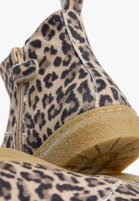 Stivaletti alla caviglia con stampa leopardata, in suede texturizzato, chiusura con cerniera e suola in gomma. Presentano una punta rotonda e finiture cucite.