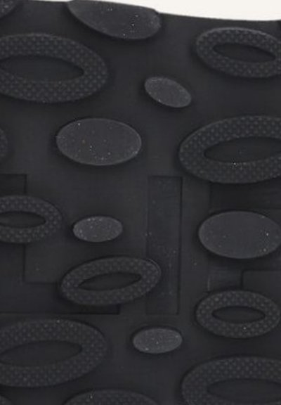Tapis en caoutchouc noir avec diverses formes ovales texturées, des zones rectangulaires plates et de petites accents tachetés sur l'ensemble de la surface.